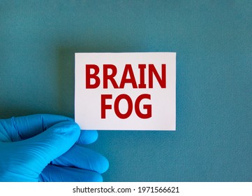 Medical, COVID-19 Pandemic Coronavirus Brain Fog Symbol. Doctor Hand Holds White Card With Words 'brain Fog'. Metallic Pen. Beautiful White Background. Copy Space. Medical, Covid-19 Brain Fog Concept.