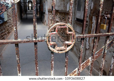 Medical Cross Symbol in the Bars of an Abandoned Prison Hospital Cell Block