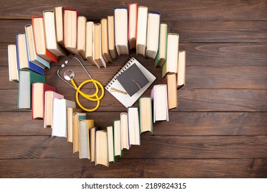 Medical Degree Education Concept - Stack Of Books In Heart Shape And Stethoscope In The Library. Love To Study Medicine