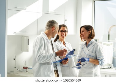 Medical dentist team in dental office   examining list of patients.