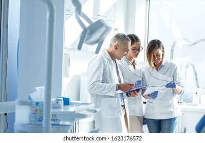 Medical dentist team in dental office examining list of patients.