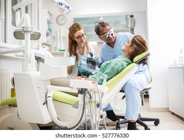 Medical dentist team in dental office talking with female patient and preparing for treatment.