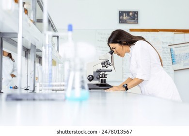 Medical Development Laboratory Female Scientist Looking Under Microscope. - Powered by Shutterstock