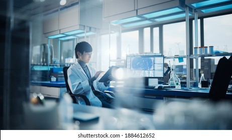 Medical Development Laboratory: Portrait Of Asian Male Scientist Using Touch Screen Digital Tablet Computer, Doing Data Analysis Research. Biotechnology Specialists In Advanced Scientific Lab.