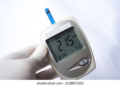 Medical Device To Check Uric Acid, Blood Sugar And Cholesterol. High Cholesterol White Background