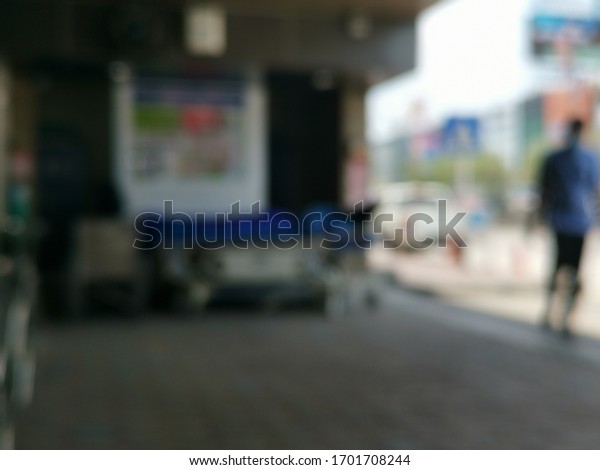 Medical disability mobility care service concept\
with blur wheelchairs and stretchers background in front of blurry\
hospital center at drop-off car parking area at building entrance\
hall