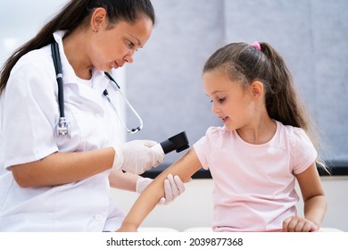 Medical Doctor Examining Child Doctor Using Dermatology Device