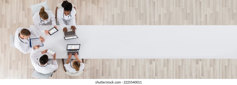 Medical Doctor Group Meeting At Desk With Laptop Computer - Powered by Shutterstock