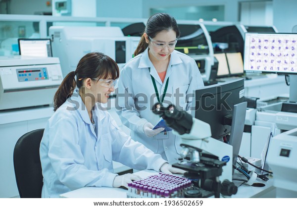 Medical doctor or health care professional working\
for analyzing blood samples in laboratory of scientific research.\
Concept for biology chemistry HIV hematology and medical equipments\
safety lab.