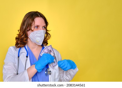 A Medical Doctor Keeps A Salary In Us Dollars, Copy Space For Text. A Nurse With Money For Work And A Protective Mask On A Yellow Background.