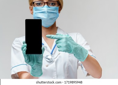 Medical Doctor Nurse Woman Wearing Protective Mask And Gloves - Using Mobile Phone