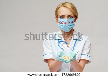 medical doctor nurse woman wearing protective mask and rubber or latex gloves - holding pills