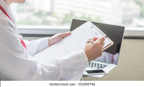 Medical doctor or physician with personal patient's health record pad in hospital or clinic - Powered by Shutterstock