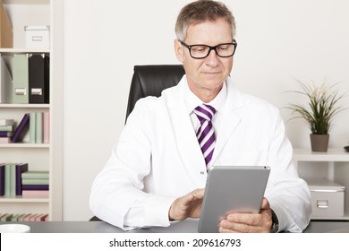 Medical Doctor Reading Client Progress Reports Using Tablet