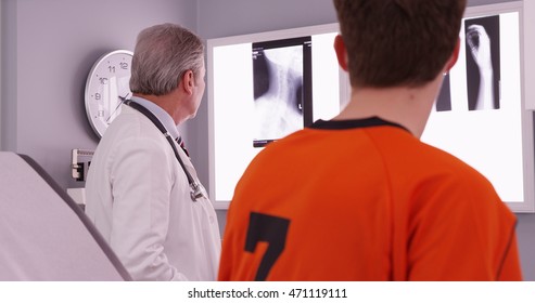 Medical Doctor Reviewing Sports Athlete's Neck Injury Xrays.