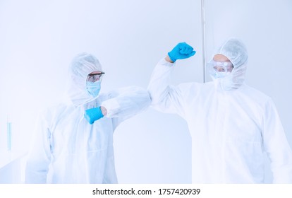 Medical Doctor, Scientist Wear PPE Suit Use Elbow Bump For Greeting In Laboratory.