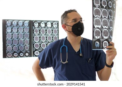 Medical Doctor Specialized In Neurology With A Mask And A Gown Uniform Reviews X-rays Of The Brain Or CT Scans As His Professional Work
