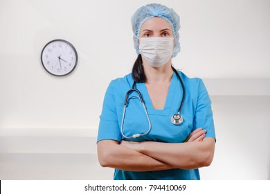 Medical Doctor With Stethoscope On White Background. Female Nurse Wearing Surgical Mask And Hat. Caucasian Woman Portrait.