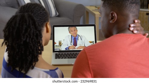 Medical Doctor Talking To Young Black Couple About Neck Pain Over Video Chat