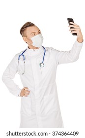 Medical Doctor In White Coat With Stethoscope And Mask Taking A Selfie With Front Camera Smiling.Isolated Over White Background.