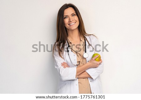 medical doctor woman smile with stethoscope hold dreen fresh apple in hand. Isolated over white background.