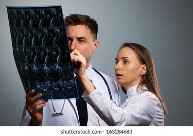 Medical doctors team with MRI spinal scan portrait against grey background  - Powered by Shutterstock