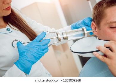 Medical Ear Washing With Water In Big Syringe. Ear Irrigation And Earwax Removal