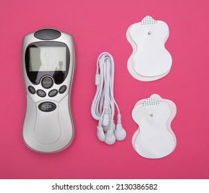 medical electric acupuncture massager in modern medicine. Treatment of body pain and fat burning, pink background.