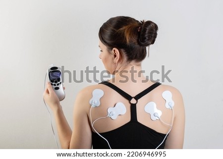 medical electric acupuncture massager on the body of a girl. Fat burning and health promotion. Physiotherapy
