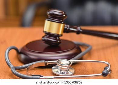 Medical Error And Trial. Forensic Medicine. Trial Of Doctor. Judge's Gavel, Doctor's Statoscope On The Table In The Courtroom.