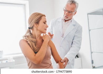 Medical examination on patient shoulder in clinic. Traumatology, orthopedist