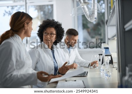 Medical experts talking while working on medical research in laboratory.