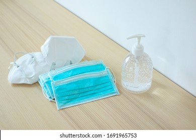 Medical face mask with alcohol sanitizer gel hand wash on wood table for covid-19 Coronavirus prevention concept - Shutterstock ID 1691965753