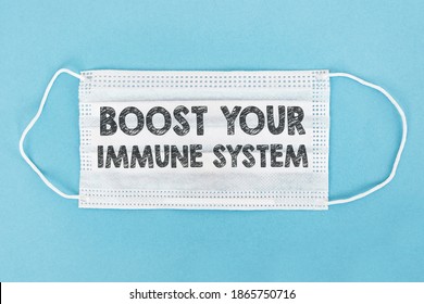 Medical face mask with Boost your Immune System text on a blue background. - Shutterstock ID 1865750716