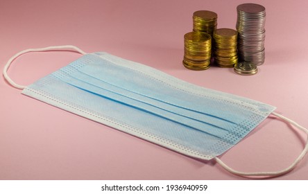 Medical Face Mask And Coins On A Pink Background, Medicine Shortage Concept