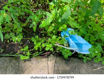 Medical Face Mask On Ground. Used Surgical Mask Isolated On Grass. Improper Disposal Of Used Protective Equipment. Lost Mask. Coronavirus Covid-19 Pandemic. Top View Natural Light.