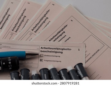 Medical forms for work incapacity certification with pens on top.