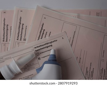 Medical forms for work incapacity certification with a bottle of glue on top.