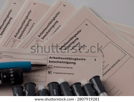 Medical forms for work incapacity certification with pens on top.