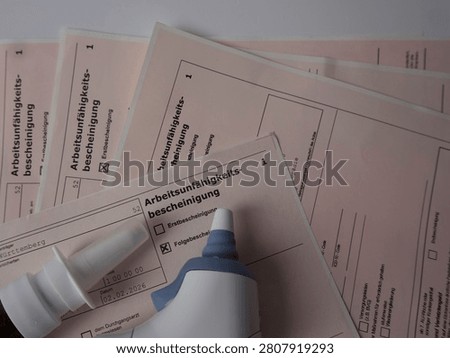 Medical forms for work incapacity certification with a bottle of glue on top.
