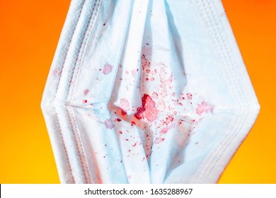 Medical Gauze Mask In Dried Blood Coronnavirus On An Orange Background. Close Up Copy Space