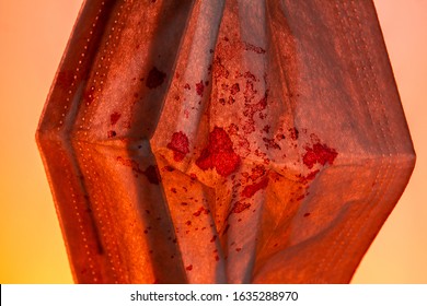 Medical Gauze Mask In Dried Blood Coronnavirus On An Orange Background. Close Up Copy Space