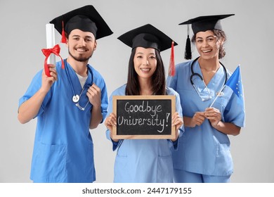 Medical graduate students holding chalkboard with text GOODBYE UNIVERSITY, diploma and EU flag on white background - Powered by Shutterstock