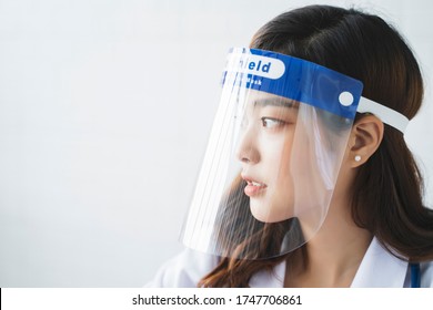 Medical Healthcare Beautiful Asian Doctor Wearing Face Shield Mask Protection From Infectious Disease Virus Bacteria Germs Coronavirus Covid-19, Safety Protection Working In Hospital Modern Office 