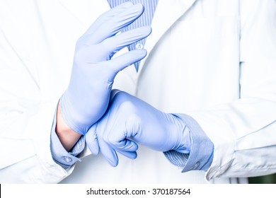 Medical healthcare. Doctor hand in gloves in hospital.  Professional medicine health clinic practitioner. Adult person. People in white uniform, coat in lab. Happy confident man, male.  - Shutterstock ID 370187564