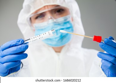 Medical healthcare NHS technician holding COVID-19 swab collection kit,wearing white PPE protective suit mask gloves,test tube for taking OP NP patient specimen sample,PCR DNA testing protocol process - Shutterstock ID 1686020212