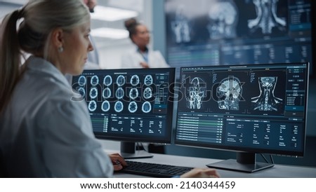 Medical Hospital Health Care Lab: Camera Captures Professional Neuroscientists Analysing CT Scan Finding Cure for Sick Patient and Female Neurologists Using Computer with Brain Scan MRI Images