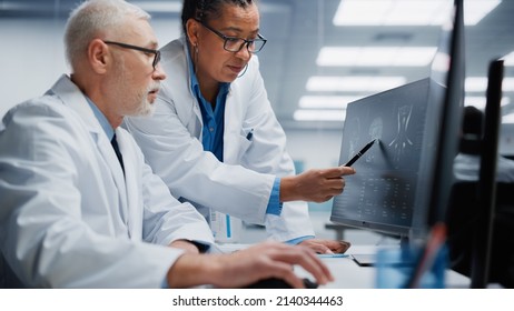 Medical Hospital: Neurologist and Neurosurgeon Talk, Use Computer, Analyse Patient MRI Scan, Diagnose Brain. Health Clinic Lab: Two Professional Physicians Look at CT Scan. Closeup Portrait - Powered by Shutterstock