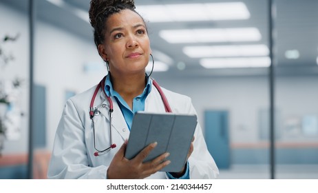 Medical Hospital Portrait: Confident African American Female Medical Doctor Using Digital Tablet Computer. Health Care Black Physician in White Lab Coat Prescribes Medicine, Ready to Save Lives - Powered by Shutterstock