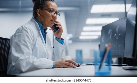 Medical Hospital Research Lab: Black Female Neurosurgeon Using Computer With Brain Scan MRI Images, Talking On The Phone With Sick Patient. Health Care Neurologist Finding Treatment. Energetic Arc